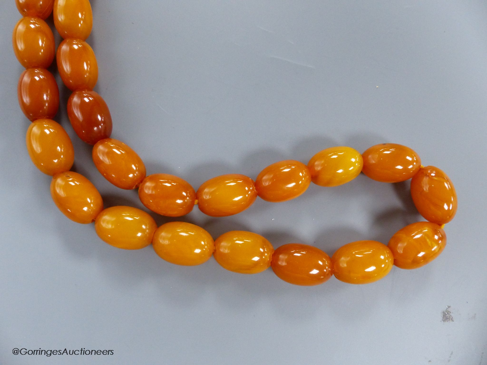 A singe strand oval amber bead necklace, 82cm, gross 45 grams.